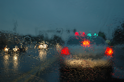 rainy view of the back of a police car with lights on