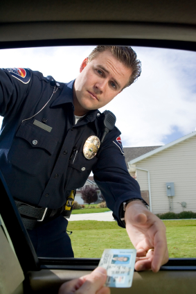 Driver handing male police officer driver's license